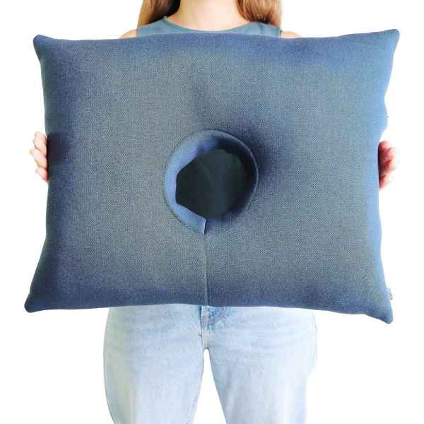Kudde med hål a person holding a pillow with a hole in the center