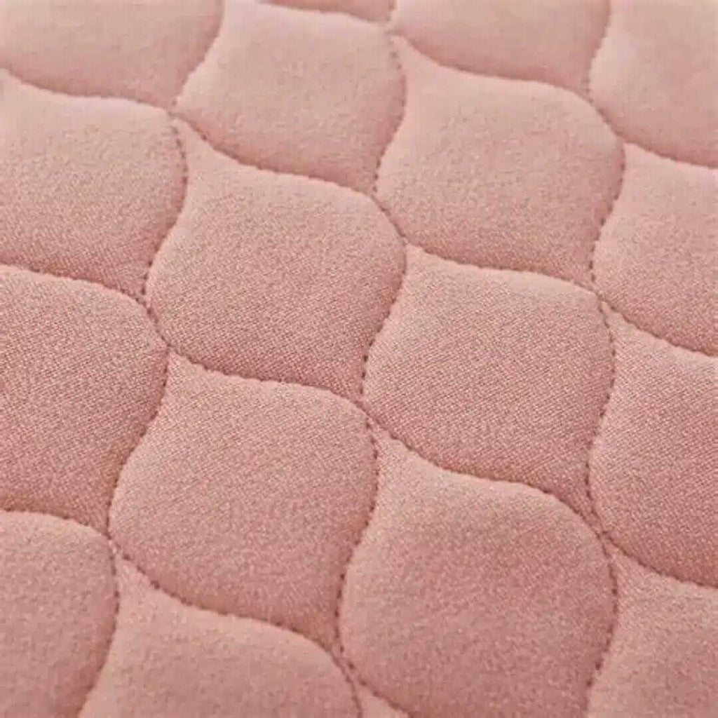 Inkontinensskydd för säng tvättbar rosa; mjukt och absorberande textilmaterial med quiltad yta.