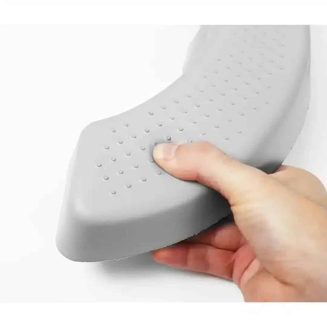 Toalettsitshöjare vadderad Hand som trycker på den mjuka ytan på en grå toalettförhöjning.