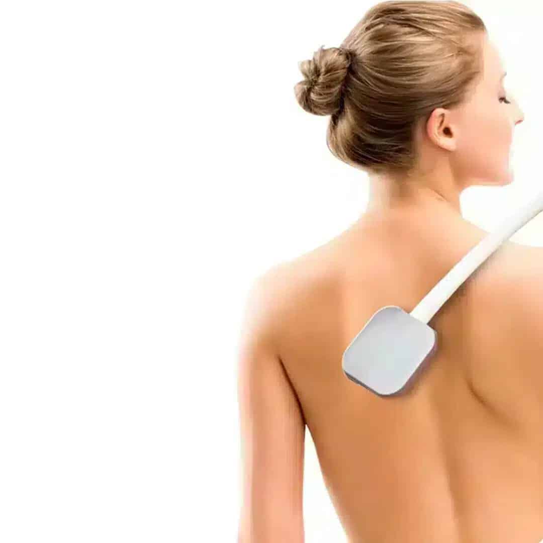Applicator för ryggkräm. Kvinna använder en lotionapplicator med långt handtag för att applicera kräm på ryggen.