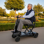 Vikbar promenadskoter vuxen PEPE svart som används av en man i park.