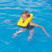 Person in water using a yellow neck float for exercise or water therapy.