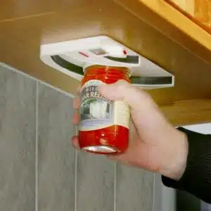 a hand holding a jar of red sauce