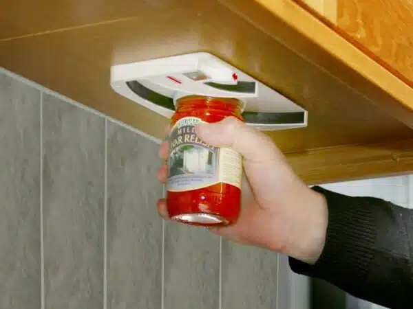 a hand holding a jar of red sauce