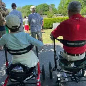Två personer sitter på rollatorer Trionic Walker 12er och pratar utomhus