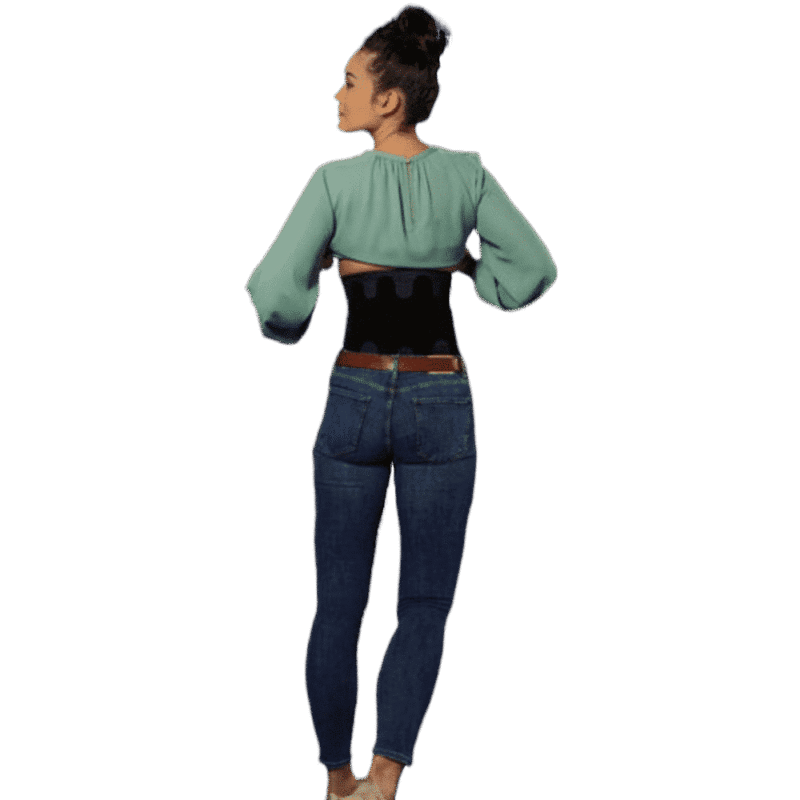 LombaSkin Ryggstöd – baksida i användning Kvinna med LombaSkin ryggstöd sett bakifrån i stående position.