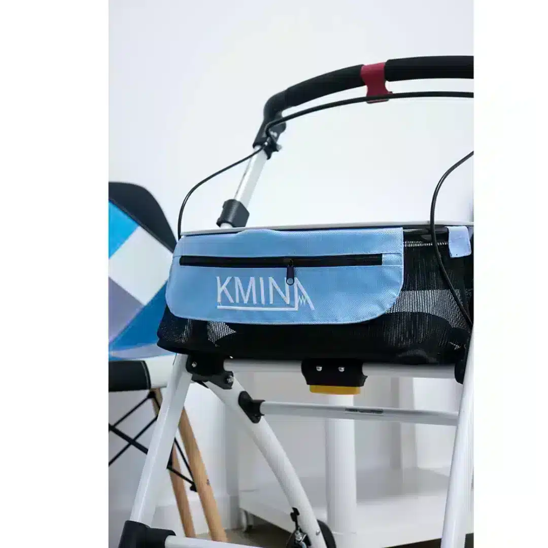 Närbild framifrån på blå korg och handtag på vit smal rollator.
