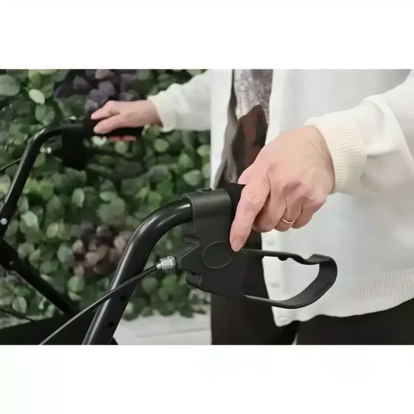 Person holding the handles of a black foldable rollator with brake function.