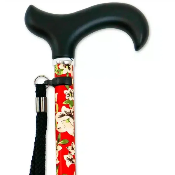 Närbild på svart ergonomiskt handtag och handledsrem till hopfällbar käpp med blommigt rött mönster