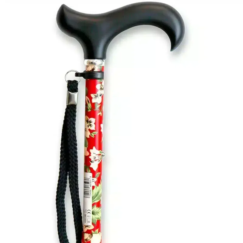 Ergonomiskt handtag och designad överdel Handtag och övre sektion av röd hopfällbar käpp med blommönster