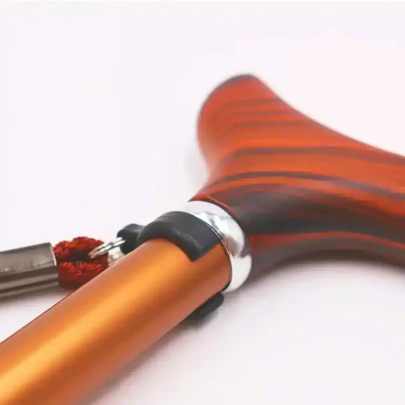 Ergonomisk form och trästruktur i detalj Liggande närbild på trähandtag med infäst handledsrem