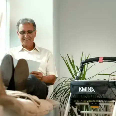 Rullator för trygg vila Man sitter och vilar bredvid sin hopfällbara rullator.