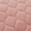 Inkontinensskydd för säng tvättbar i rosa färg, närbild på quiltad yta