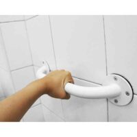 Hand holding white safety bar 30 cm mounted on bathroom wall