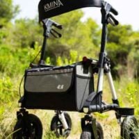 Rollator with seat and large wheels used outdoors on grass