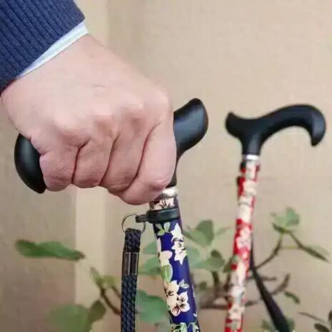 Ergonomiskt grepp vid användning Hopfällbar käpp med blommönster Hand håller i hopfällbar promenadkäpp med blått blommönster