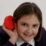 a girl holding a red object to her ear