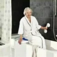 a woman in a bathrobe sitting in a bathtub