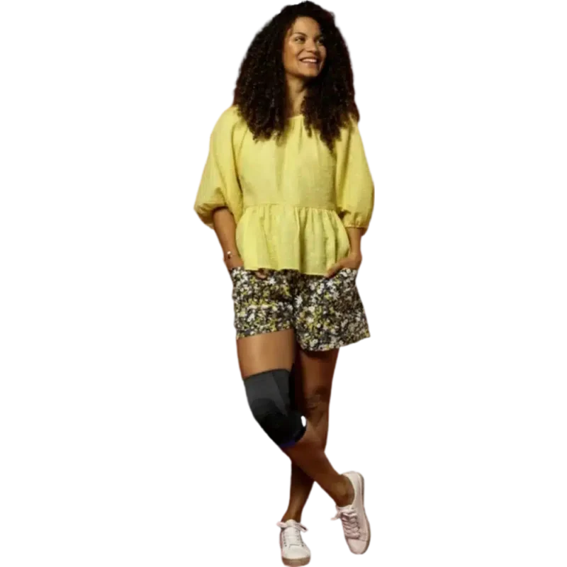 Knäskydd i vardagsanvändning Kvinna som bär ett svart knäskydd över höger knä