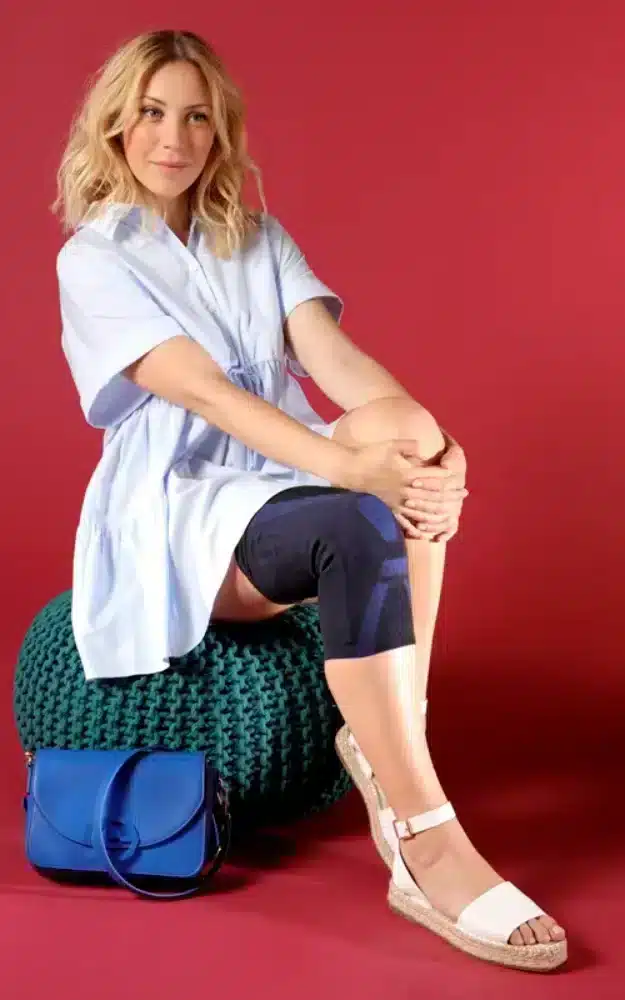 Person som bär svart knäskydd och håller händerna på knäet.