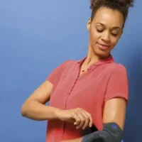 Woman adjusting her Silistab Epi elbow brace for a perfect fit.