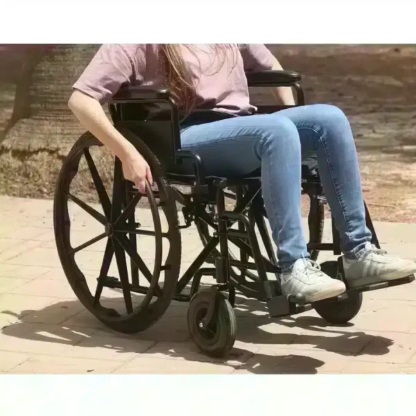 Person sitting in a black lightweight aluminum wheelchair outdoors