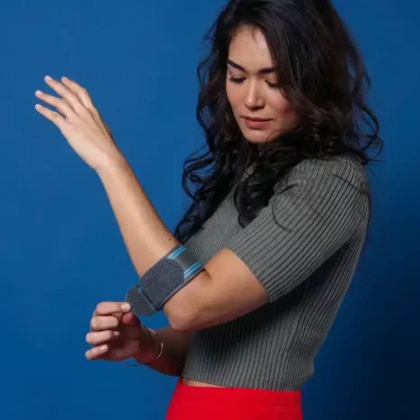 Bekvämt stöd för underarm vid tennisarmbåge Kvinna bär ortos för tennisarmbåge i stående position
