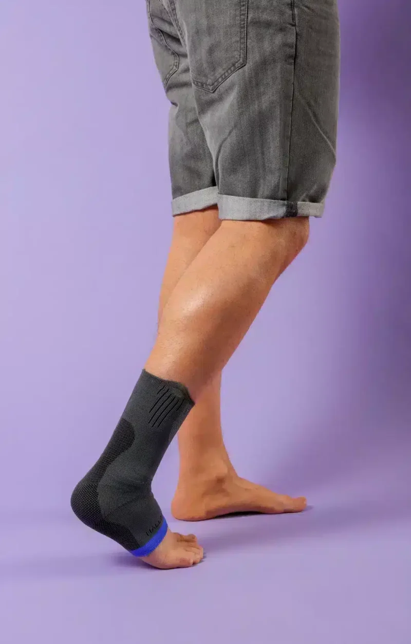 Fotledsstöd med kompression – Malleo Action Malleo Action ankelstöd visat från sidan – står upprätt mot lila bakgrund