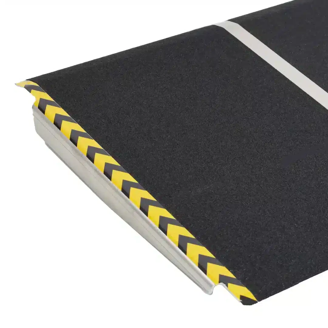 Närbild av rullstolsrampens halksäkra yta i aluminium