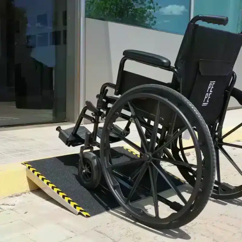 Ramp för rullstol. Rullstolsramp i användning vid entré med manuell rullstol