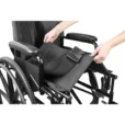 a person holding a black bag on a wheelchair