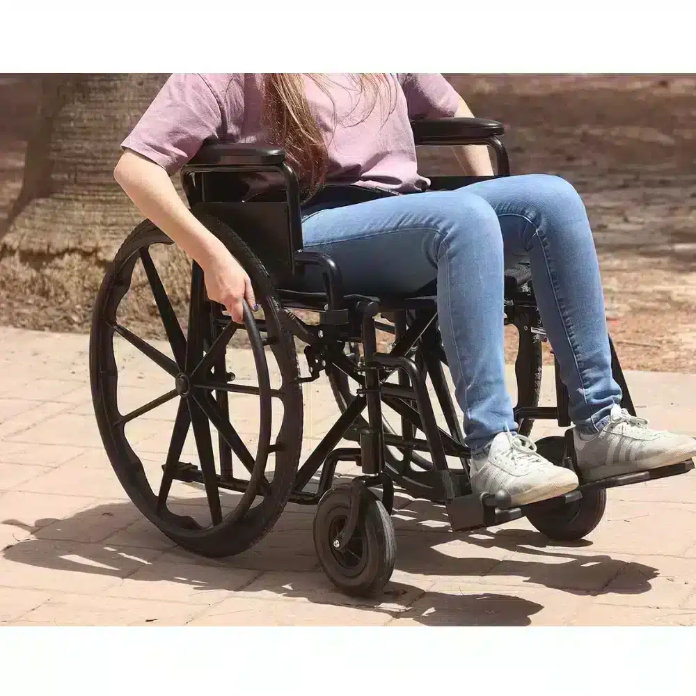 Person använder hopfällbar manuell rullstol sitsmått 43 cm utomhus.