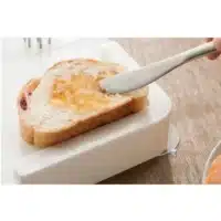 Bread is held by clamp on multifunctional cutting board
