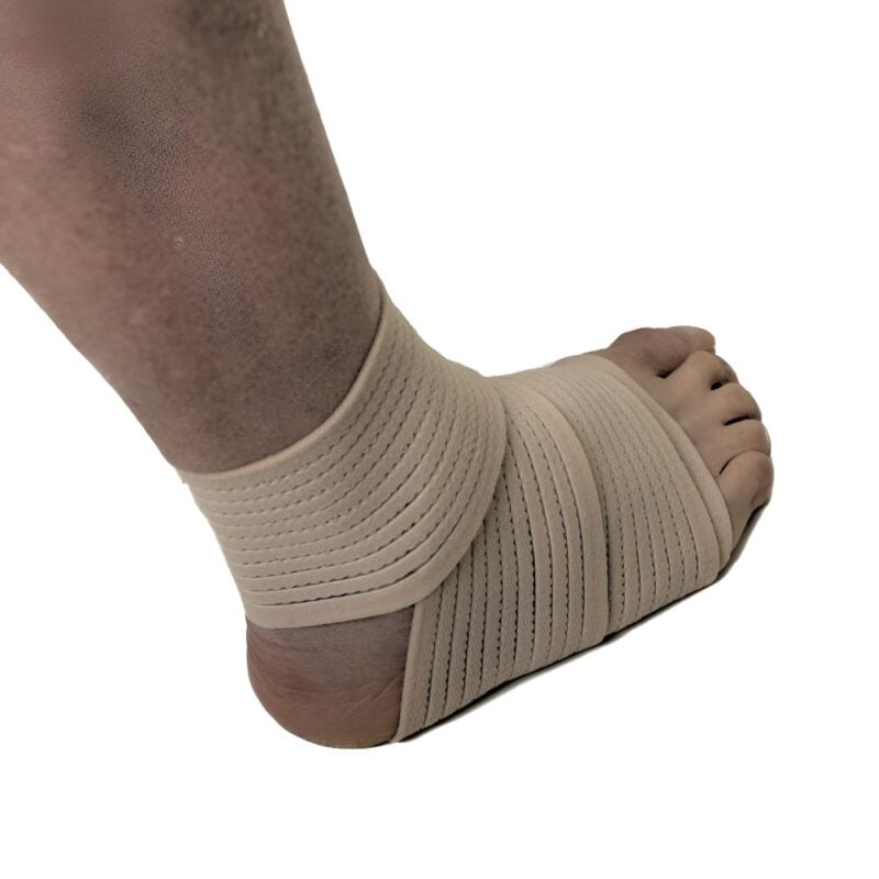 Elastisk ankelbandage i beige färg lindat runt fot och ankel