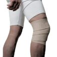 Elastisk knäbandage i beige lindat runt knäleden för jämn kompression