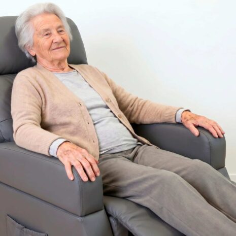 Elektrisk relaxfåtölj med uppresning och hjul med person i sittande läge Elektrisk relaxfåtölj med uppresning och hjul med person i sittande läge